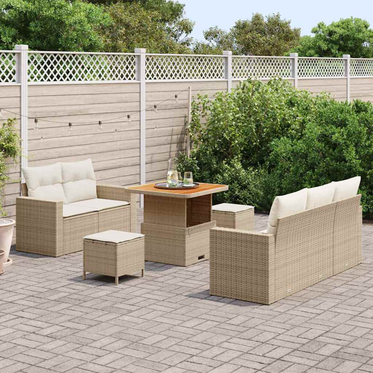Terrassenmöbel-Set aus beigem Korbgeflecht, bestehend aus Sofa, zwei Stühlen, Tisch und zwei Hockern, auf einer Backsteinterrasse.