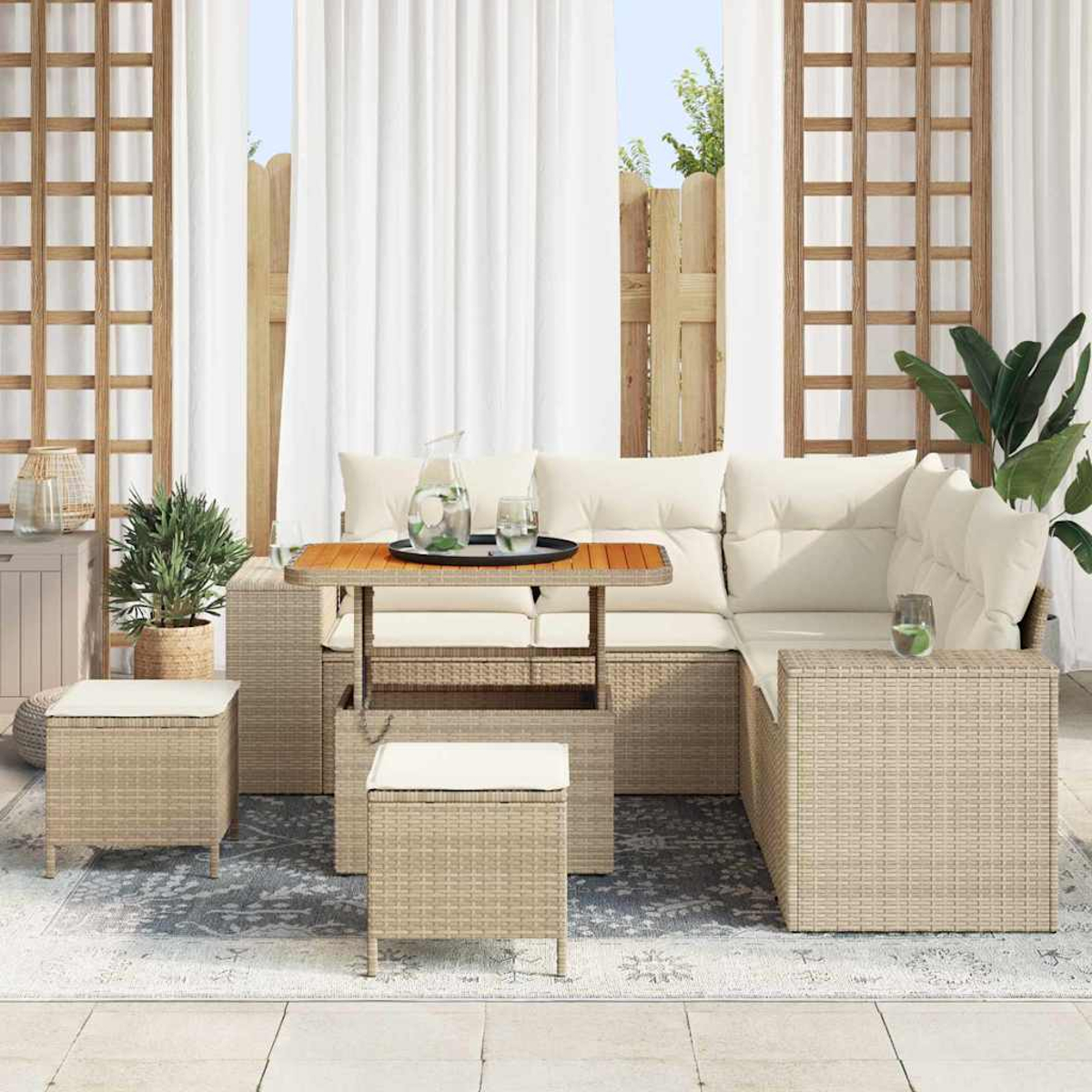 Set da patio esterno con mobili in vimini, cuscini e un tavolo. Include una pianta e tende bianche sullo sfondo.