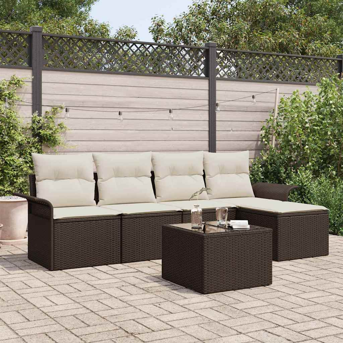 Garten-Ecksofa und Tisch auf einer Terrasse, cremefarbene Kissen, braunes Korbgeflecht. Hintergrund: Zaun und Grün.