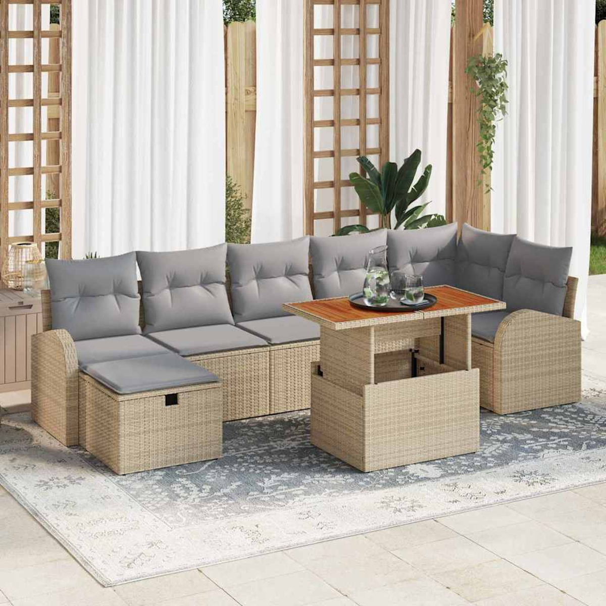 Outdoor-Rattan-Sofagarnitur mit grauen Kissen, einem Holztisch und einem gemusterten Teppich. Hintergrundvorhänge und Zierholz.