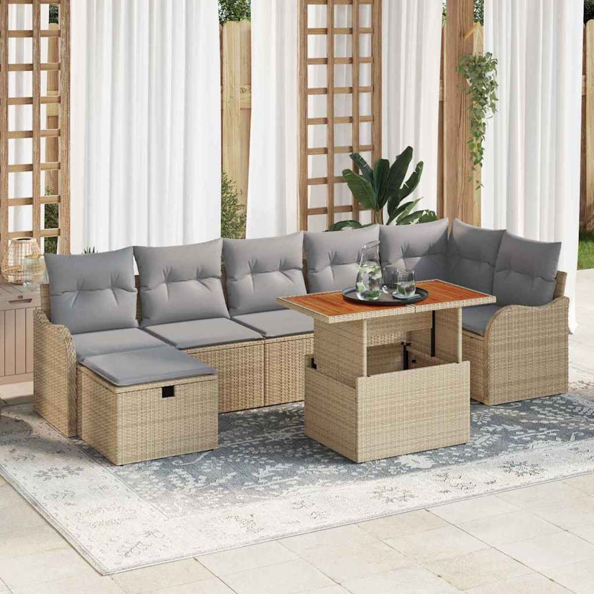 Gartenmöbel-Set aus Korbgeflecht mit grauen Kissen, einem Aufsatztisch mit Getränken und einem gemusterten Teppich.