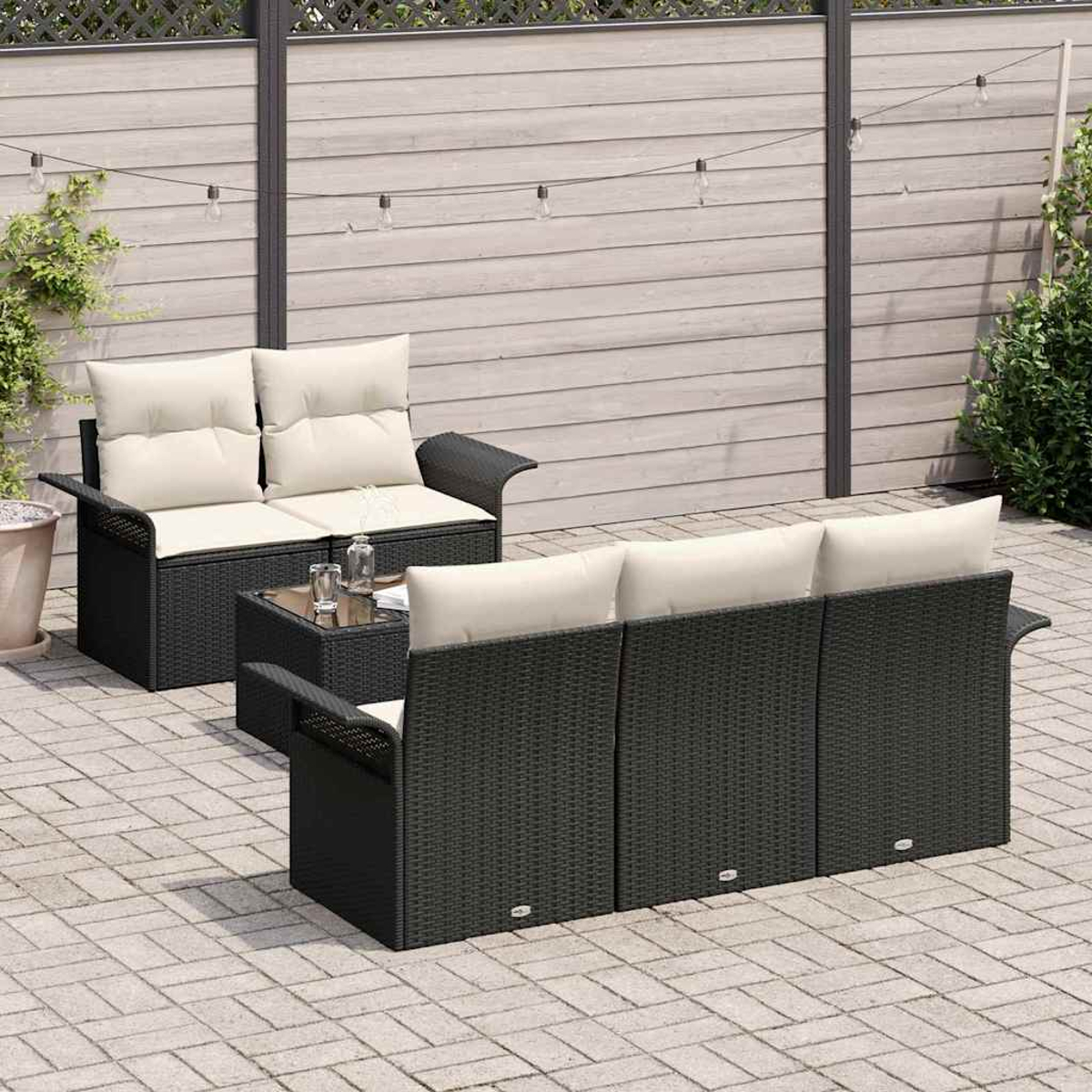 Gartenmöbel: ein schwarzes Korbmöbel und ein Zweisitzer mit cremefarbenen Kissen, ein Tisch mit Glasplatte und ein Zaun im Hintergrund mit Lichterkette.