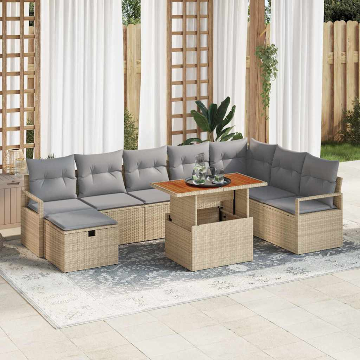 Gartenmöbel-Set mit grauen Kissen, Holztisch und hellen Korbgeflecht. Auf einem gemusterten Teppich, in der Nähe von weißen Vorhängen.