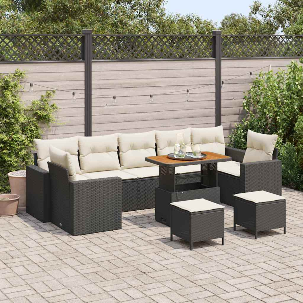Set da patio esterno con mobili in vimini grigi, cuscini beige e un tavolo in legno, su un patio in mattoni.