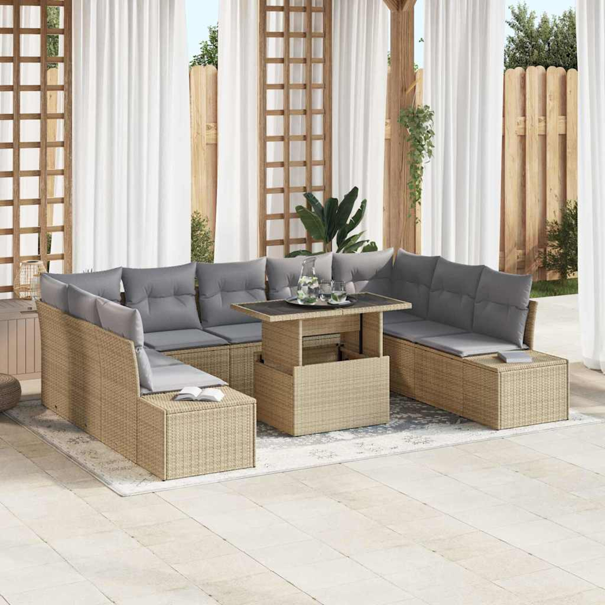Gartenmöbel-Set aus Korbgeflecht mit grauen Kissen. Ein Tisch mit Getränken steht in der Mitte. Weiße Vorhänge und Holzzaun im Hintergrund.