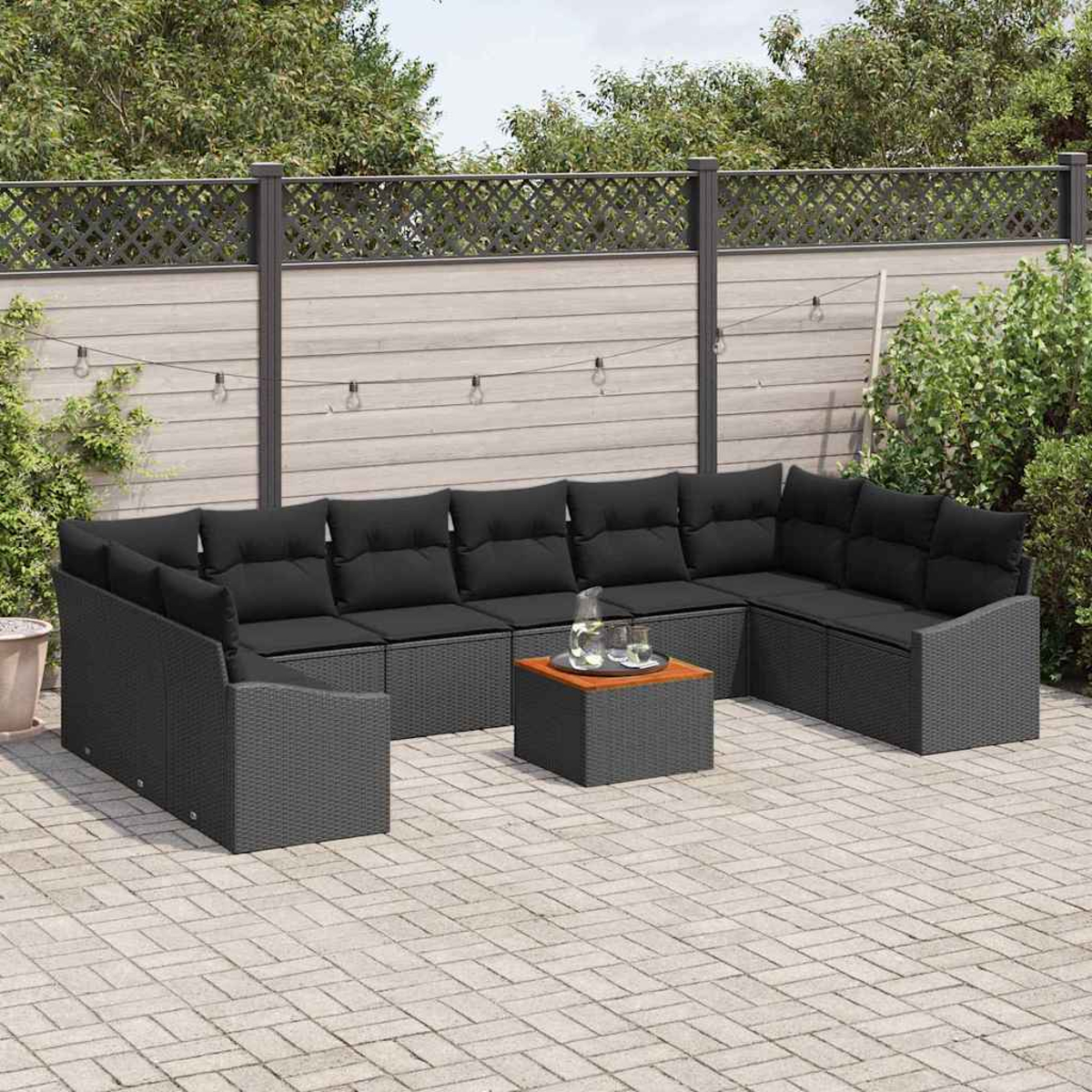 Outdoor-Ecksofa mit schwarzen Kissen und einem kleinen Tisch. Vor einem Holzzaun, mit Pflanzen und einer gepflasterten Terrasse.