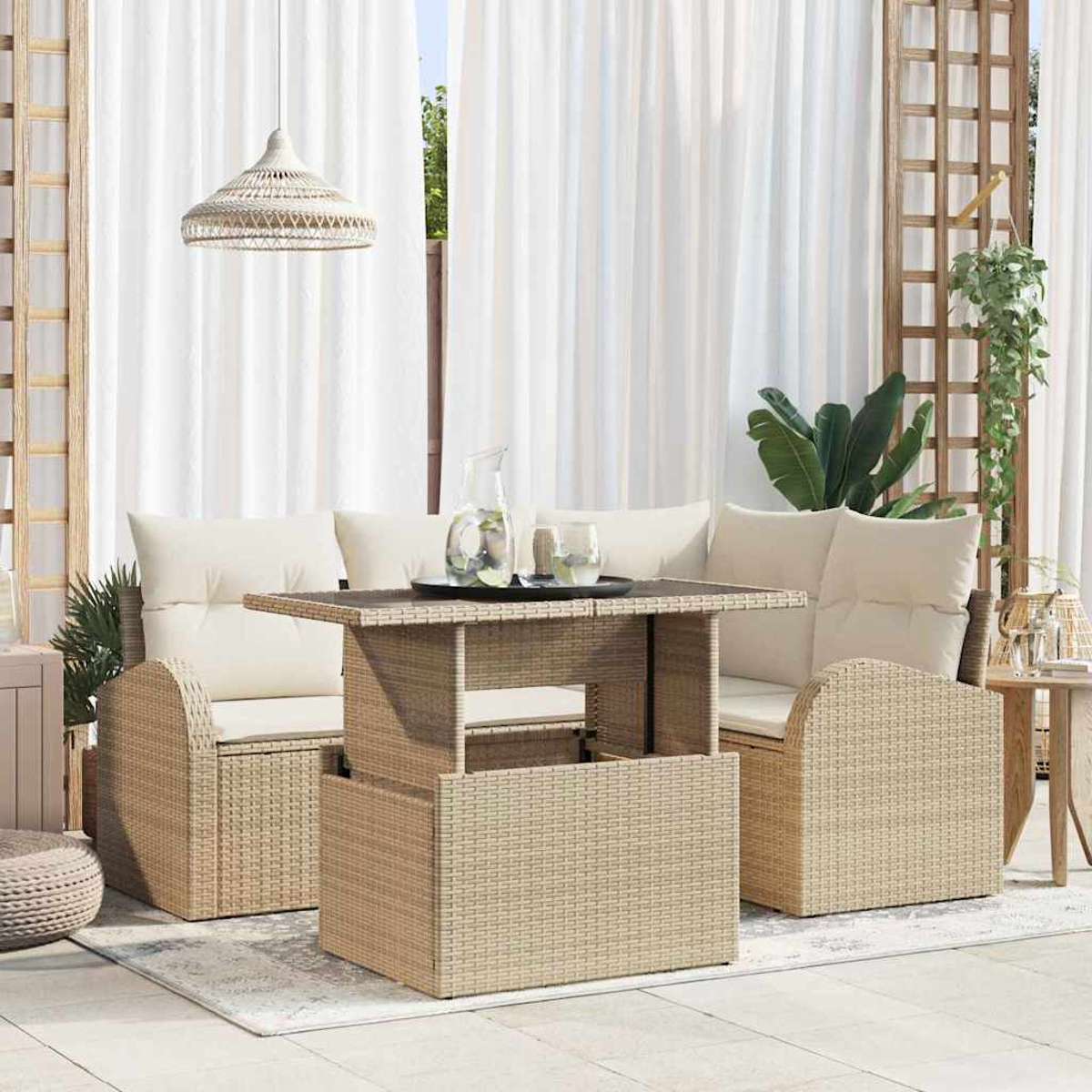 Gartenmöbel-Set aus Korbgeflecht mit Tisch, Sofa und Stuhl. Weiße Vorhänge und Hängelampe im Hintergrund. Tisch mit Getränken.