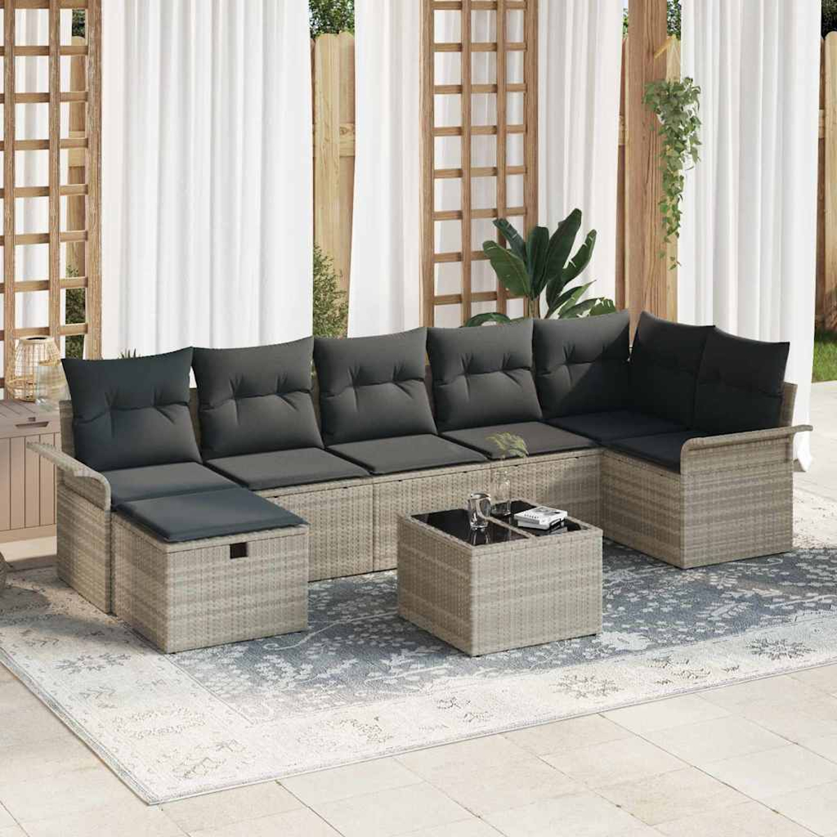 Outdoor-Sitzgruppe auf einem gemusterten Teppich, beinhaltet ein Ecksofa mit grauen Kissen und einem kleinen quadratischen Tisch mit Glasplatte.