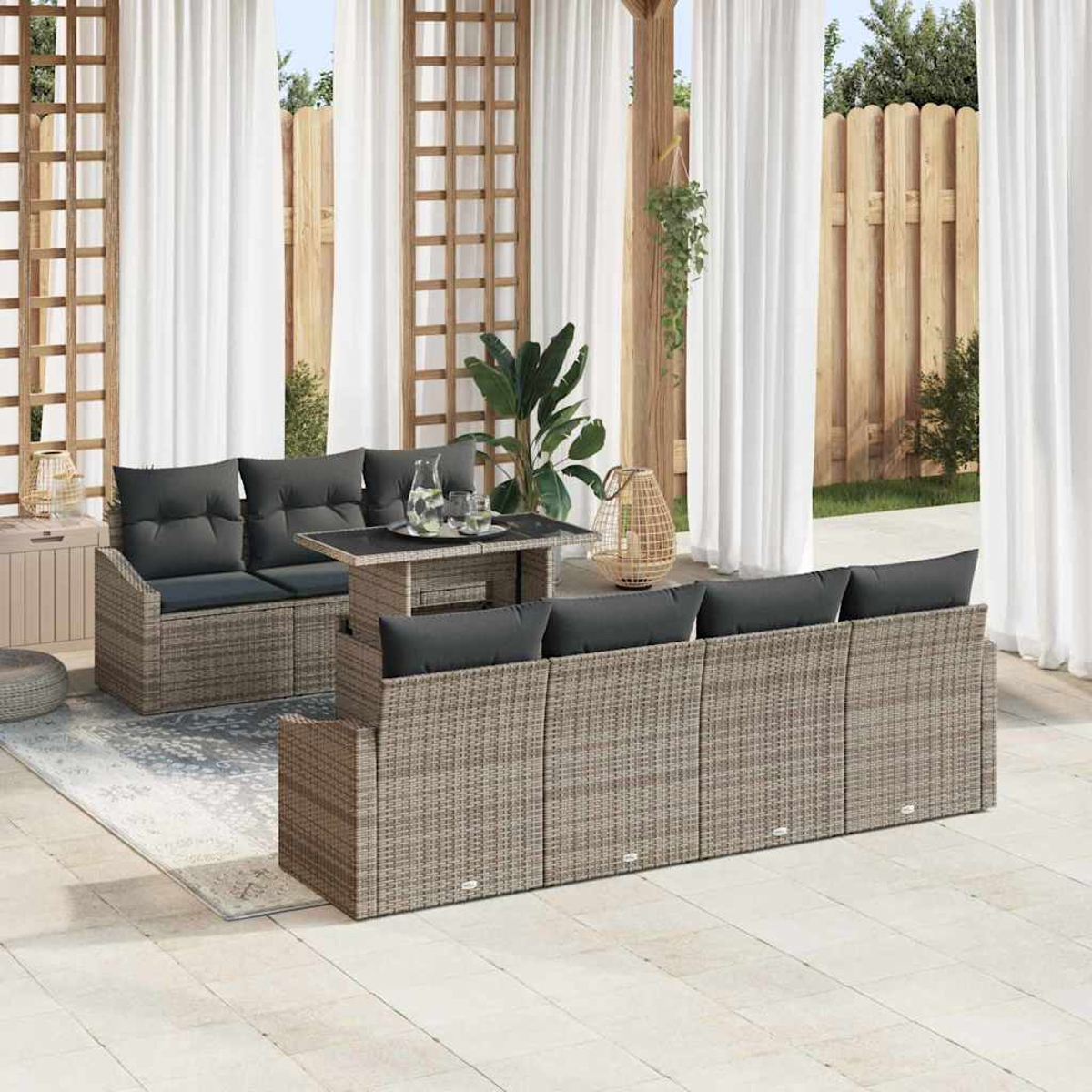 Gartenmöbel-Set mit grauen Kissen. Enthält Tisch, Sofa und Stühle auf einer Terrasse mit Vorhängen im Hintergrund.