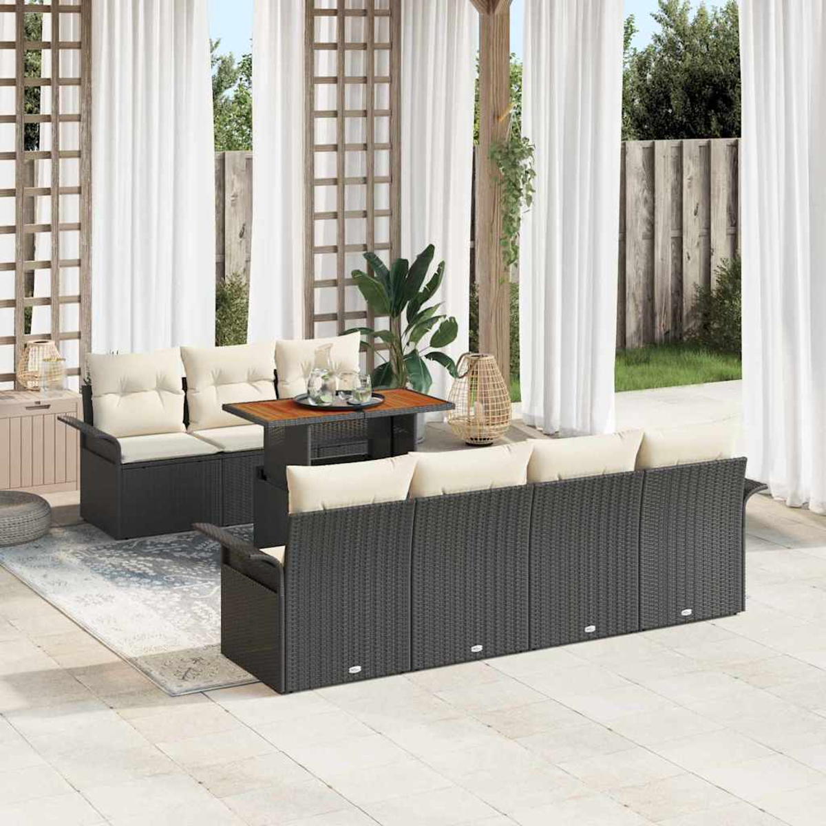Garten-Terrassenset mit schwarzen Korbsesseln, beigefarbenen Kissen, Holztisch. Weiße Vorhänge, grüne Pflanzen und Holzgitter im Hintergrund.