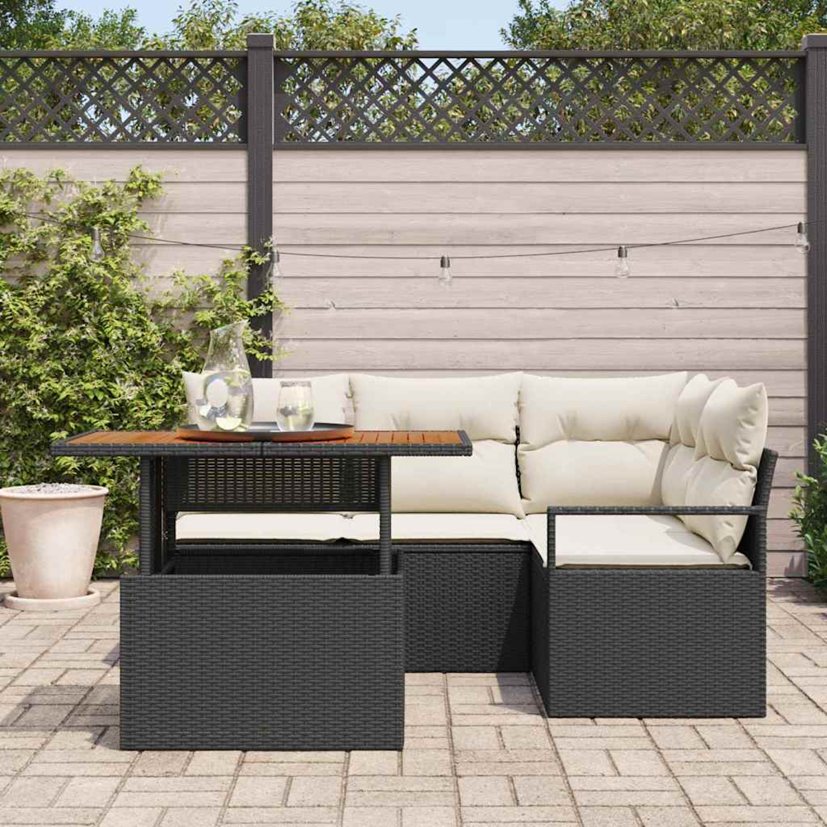 Garten-Sitzgruppe mit dunkelgrauem Korbtisch und Sitzgelegenheiten, hellen Kissen und einer Holzplatte. Hintergrund mit Zaun und Grün.