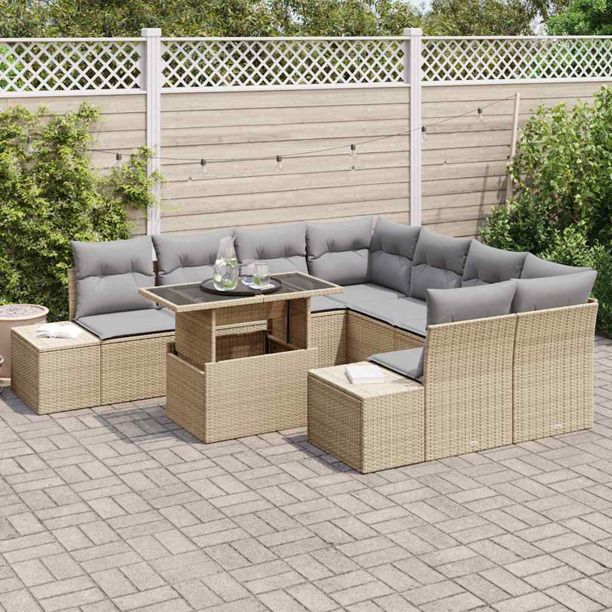 Garten-Sitzgruppe mit grauen Kissen und einem Tisch mit Gläsern darauf. Im Hintergrund ein weißer Zaun.