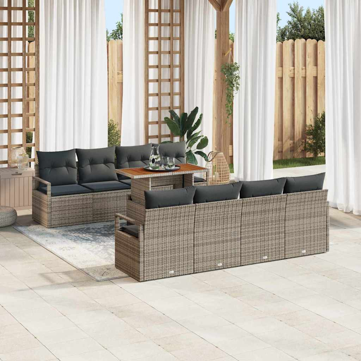 Garten-Sitzgruppe mit grauen Kissen und einem Holztisch. Weiße Vorhänge und ein Holzzaun sind im Hintergrund zu sehen.