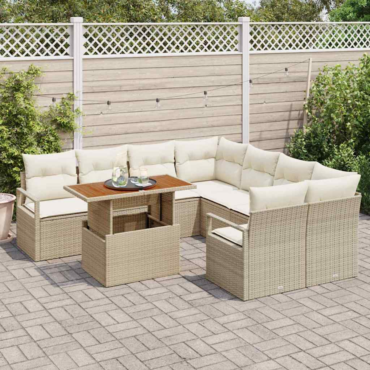 Outdoor-Wicker-Sofa mit cremefarbenen Kissen und einem Tisch mit Hebevorrichtung und Getränken. Auf einer Terrasse, mit Zaun und Grün im Hintergrund.