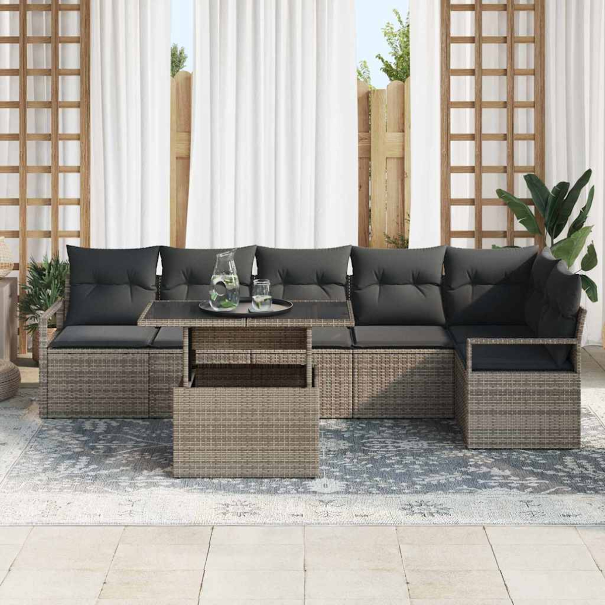 Outdoor-Ecksofa mit grauen Kissen und Couchtisch. Weiße Vorhänge und ein Holzgitter im Hintergrund.