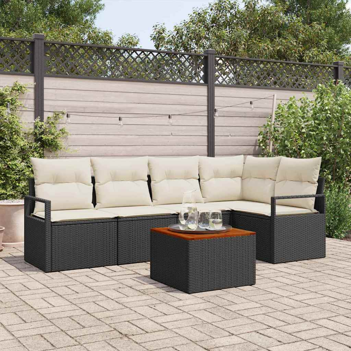 Szene im Freien mit dunkelgrauem Rattan-Ecksofa, beigen Kissen und einem Couchtisch aus Holz. Dahinter ein Zaun und Grün.