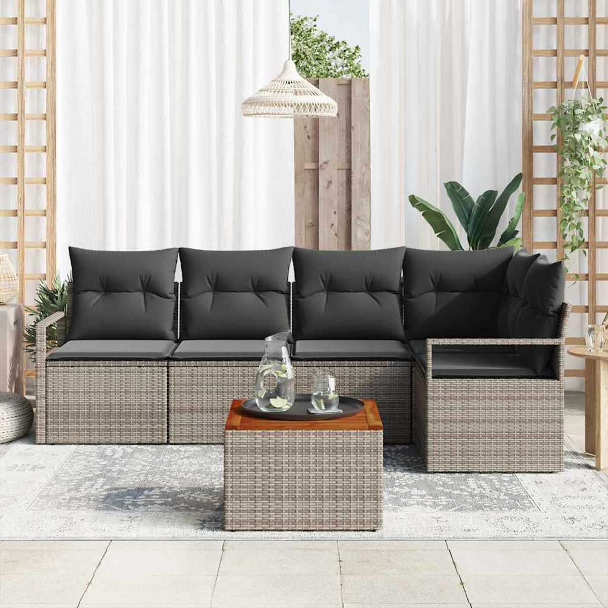 Garten-Terrassenset mit grauen Kissen, Rahmen im Korb-Stil, Couchtisch mit Getränken und weißen Vorhängen im Hintergrund.