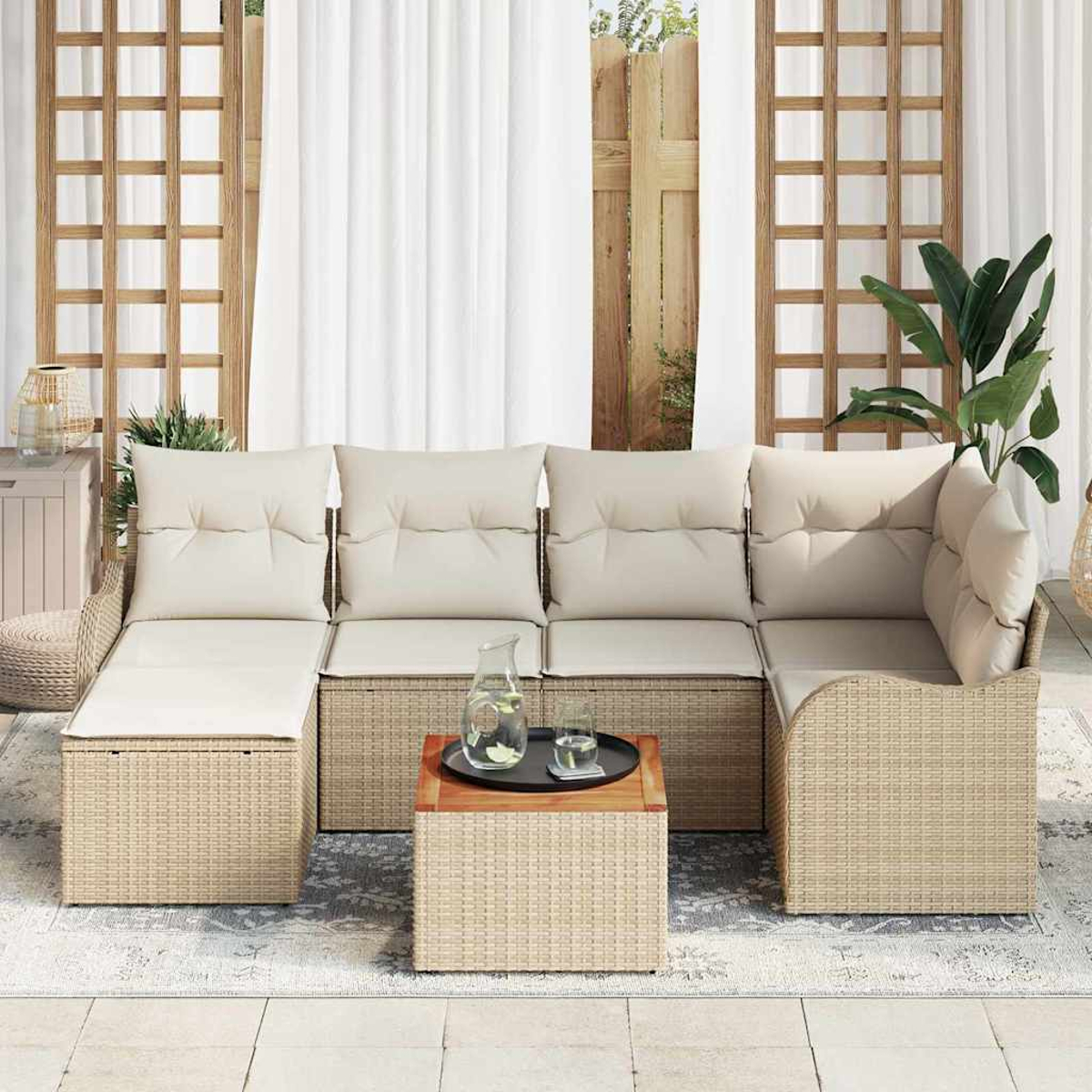 Outdoor-Ecksofa mit beigen Kissen und einem Korbgewebe-Rahmen, dazu ein Holztisch. Im Hintergrund weiße Vorhänge und ein Garten.
