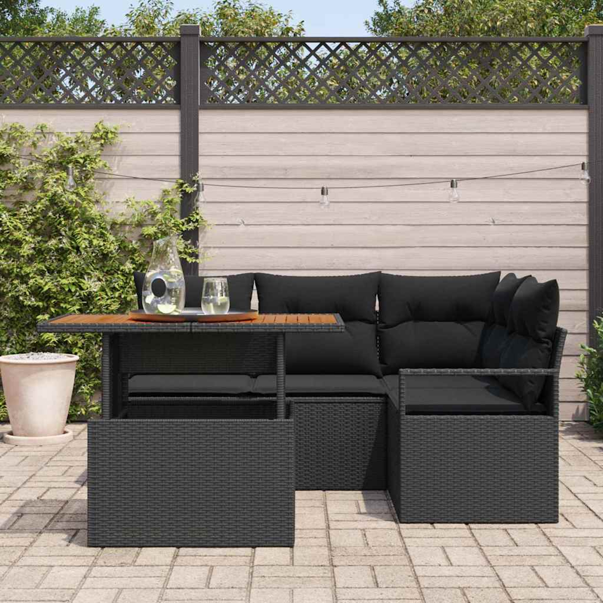 Sofá seccional exterior con cojines negros y mesa con vaso de agua. El fondo muestra una valla y algunas plantas.