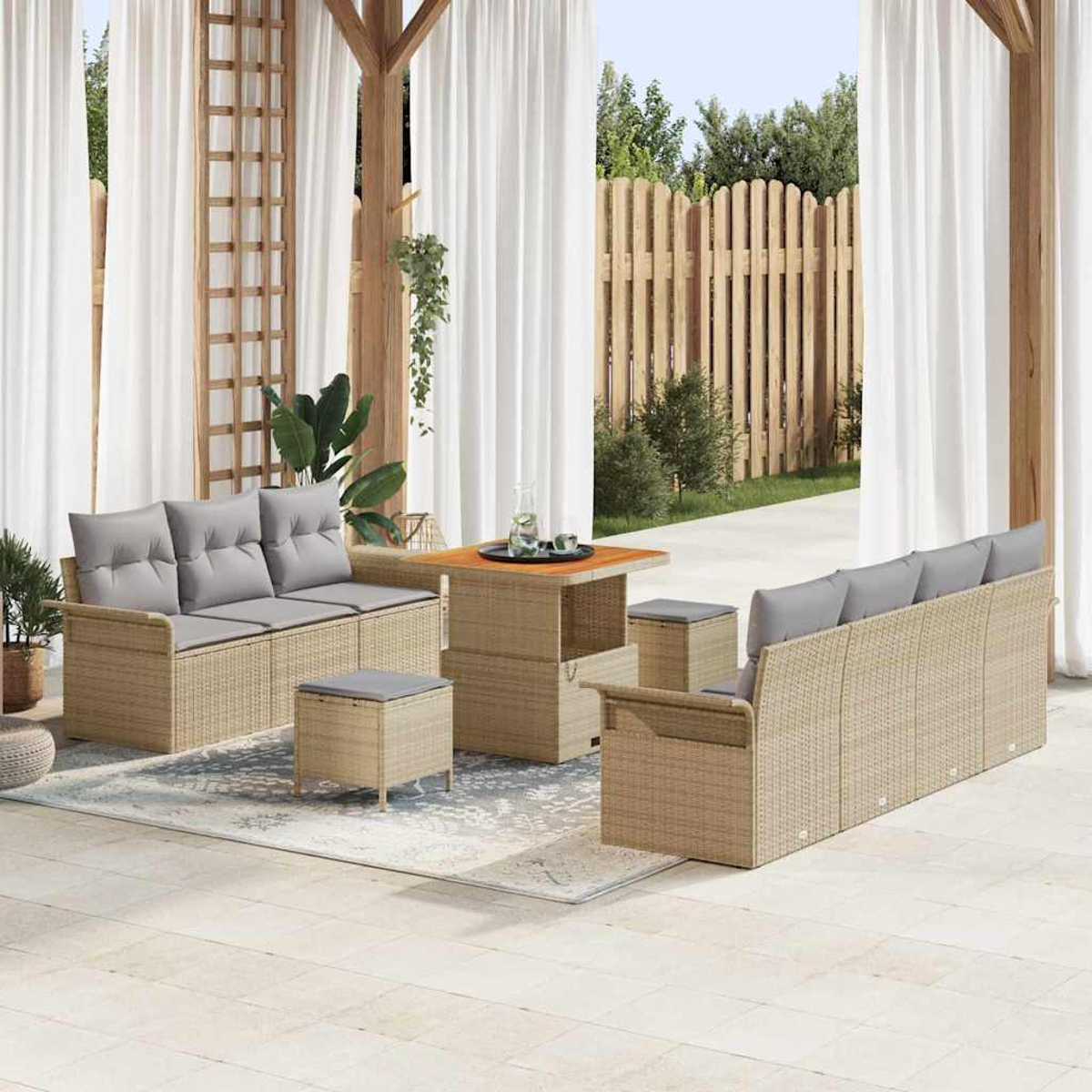 Terrassenset mit beigen Korbsessel und Hockern mit grauen Kissen, einem Holztisch, auf einem Teppich.