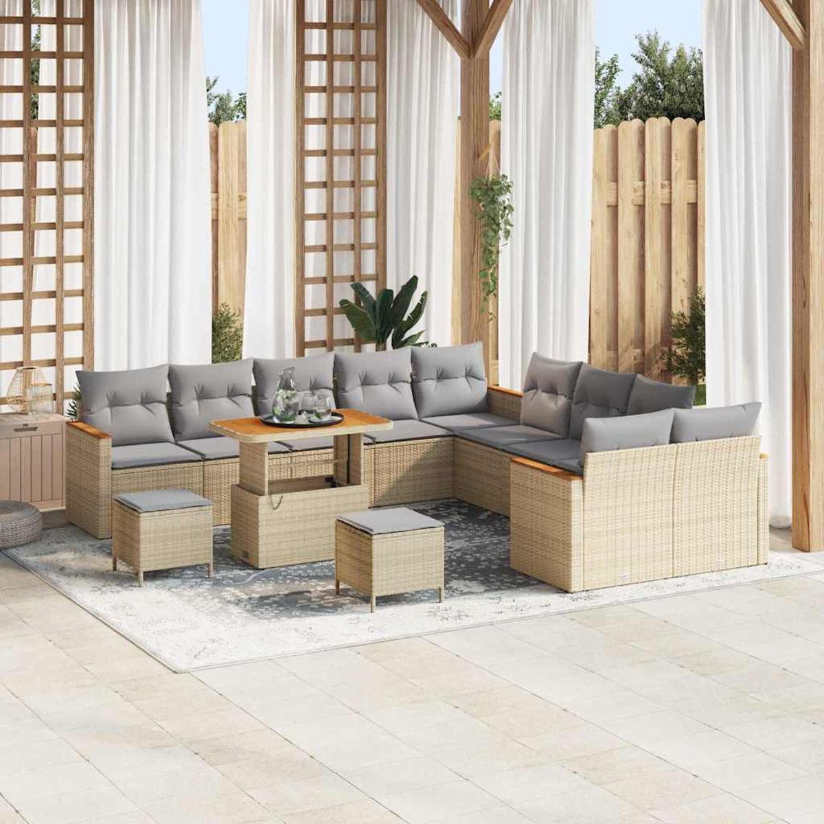 Outdoor-Sitzbereich mit Korbmöbeln, grauen Kissen und einem Holztisch. Weiße Vorhänge und ein Holzzaun sind im Hintergrund.