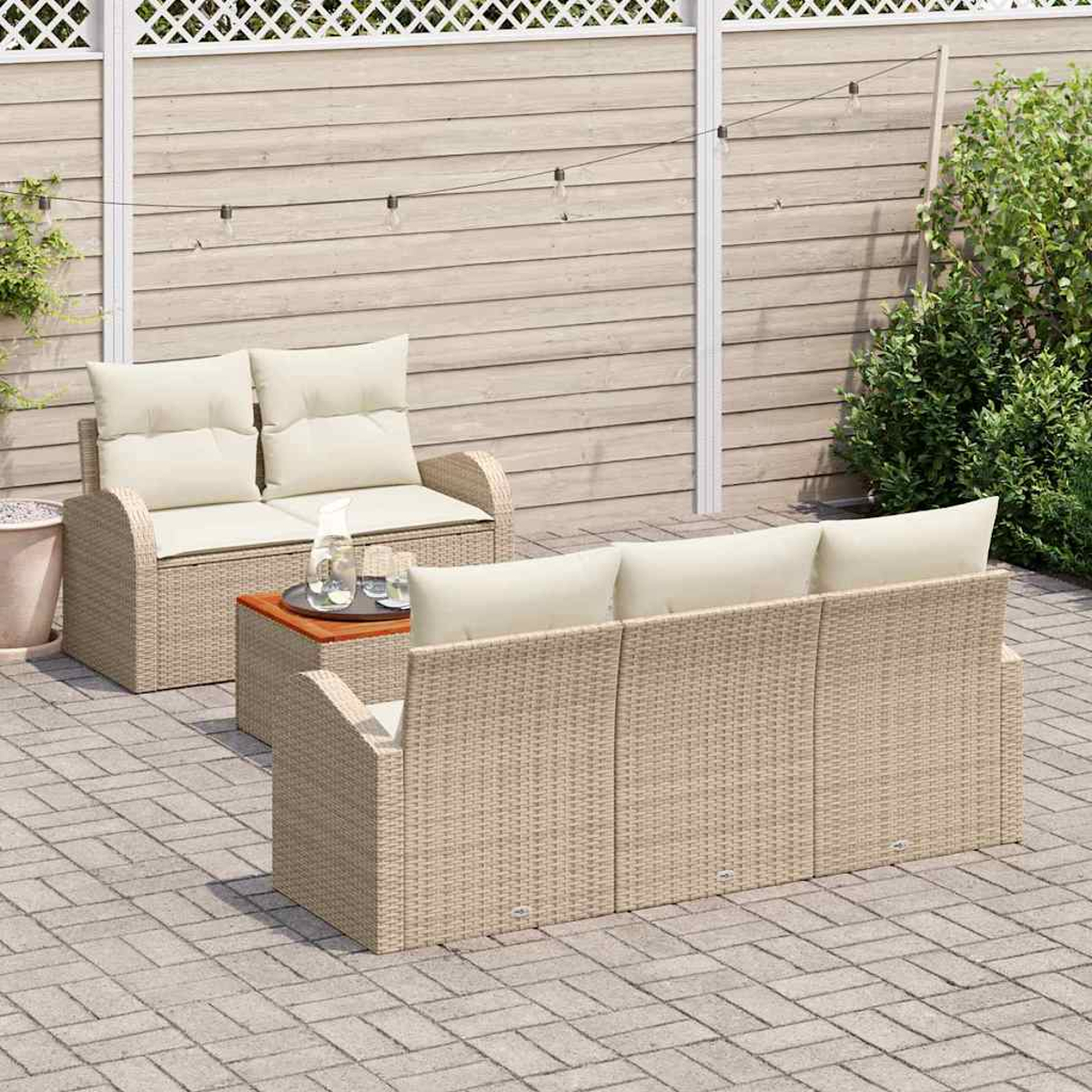 Gartenmöbel-Set. Beige Korbsessel und -liege mit cremefarbenen Kissen. Kleiner Tisch mit Getränken. Ziegelterrasse und Holzzaun.