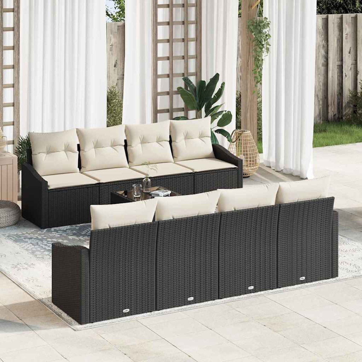 Terrassenset mit schwarzen Korbsesseln, beigen Kissen, einem Glastisch und weißen Vorhängen im Hintergrund.
