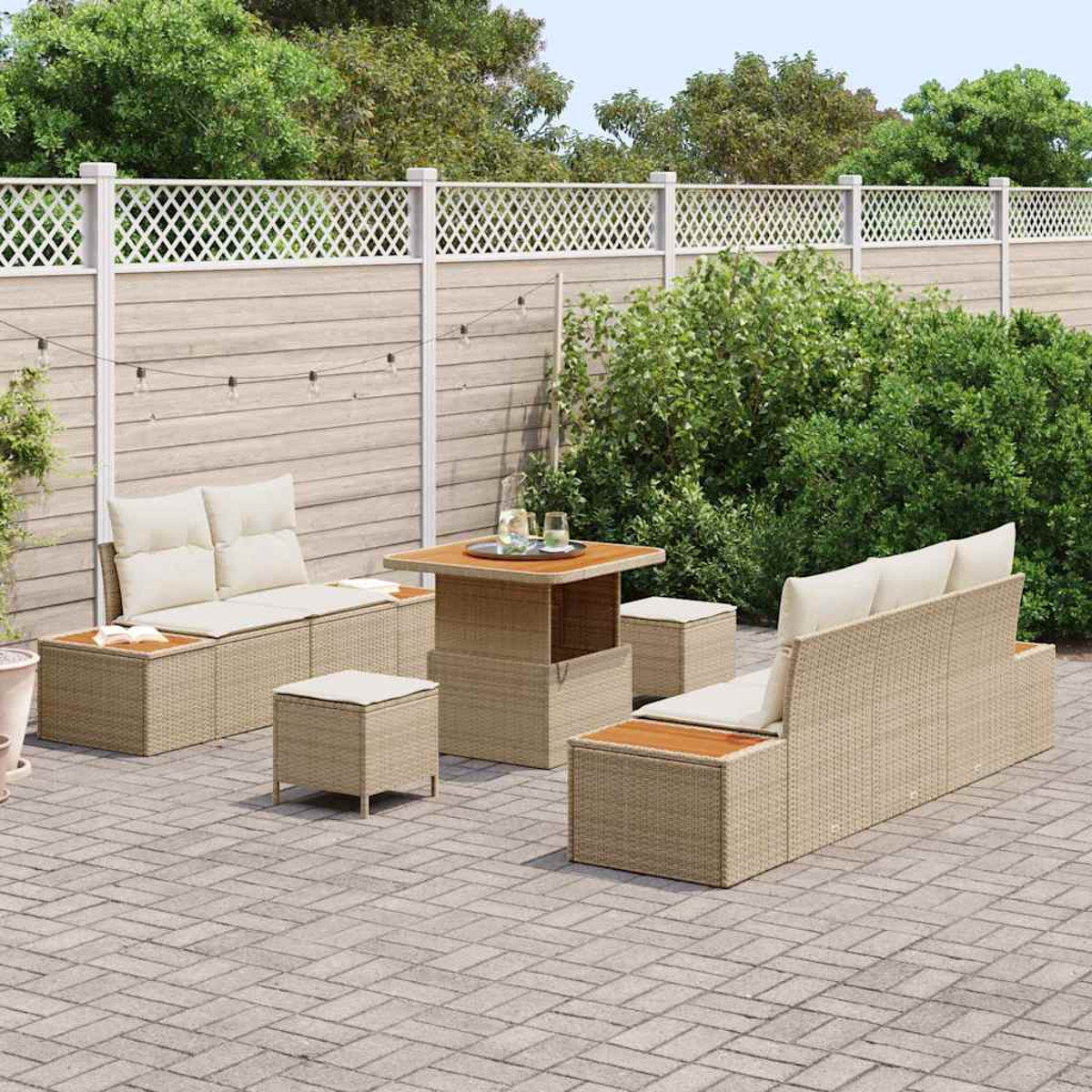 Garten-Terrassenset mit beigen Korbmöbeln, Kissen und Holztischplatten. Enthält Sofa, Tisch und Hocker auf Ziegelpflaster.