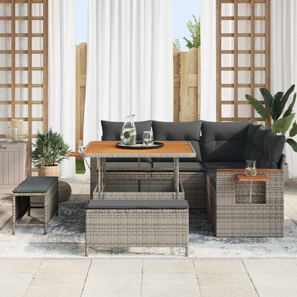 Outdoor-Ecksofa mit Holztisch, Bank und zwei Hockern. Auf dem Tisch stehen eine Kanne und Gläser. Der Hintergrund umfasst Vorhänge.