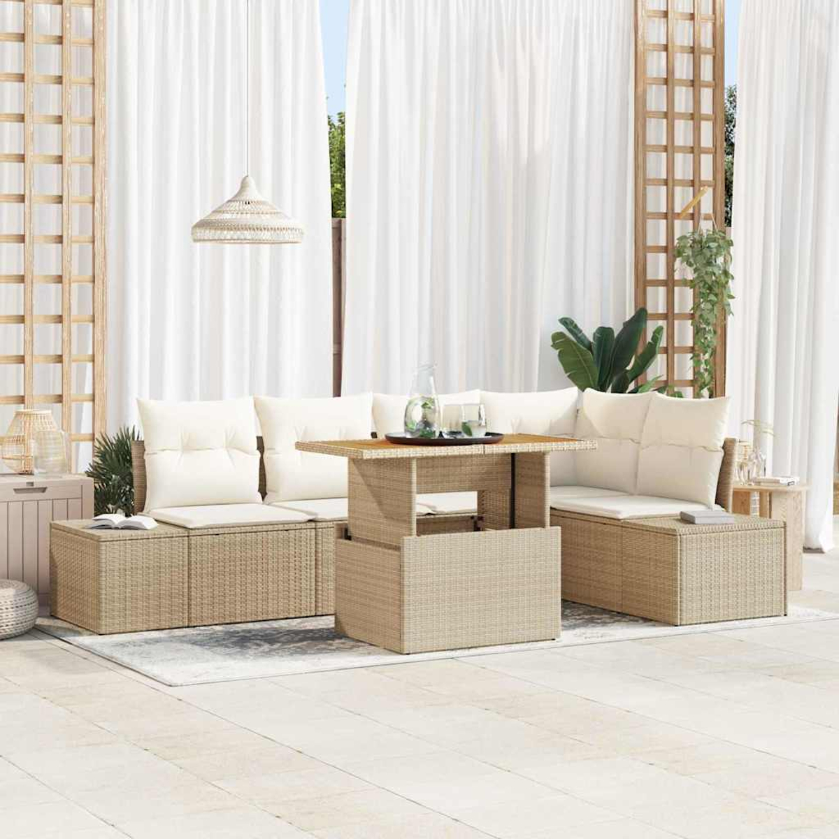 Gartenmöbel-Set aus Korbgeflecht mit beigen Kissen. Ein Hebetisch trägt Gläser. Weiße Vorhänge und Pflanzen im Hintergrund.