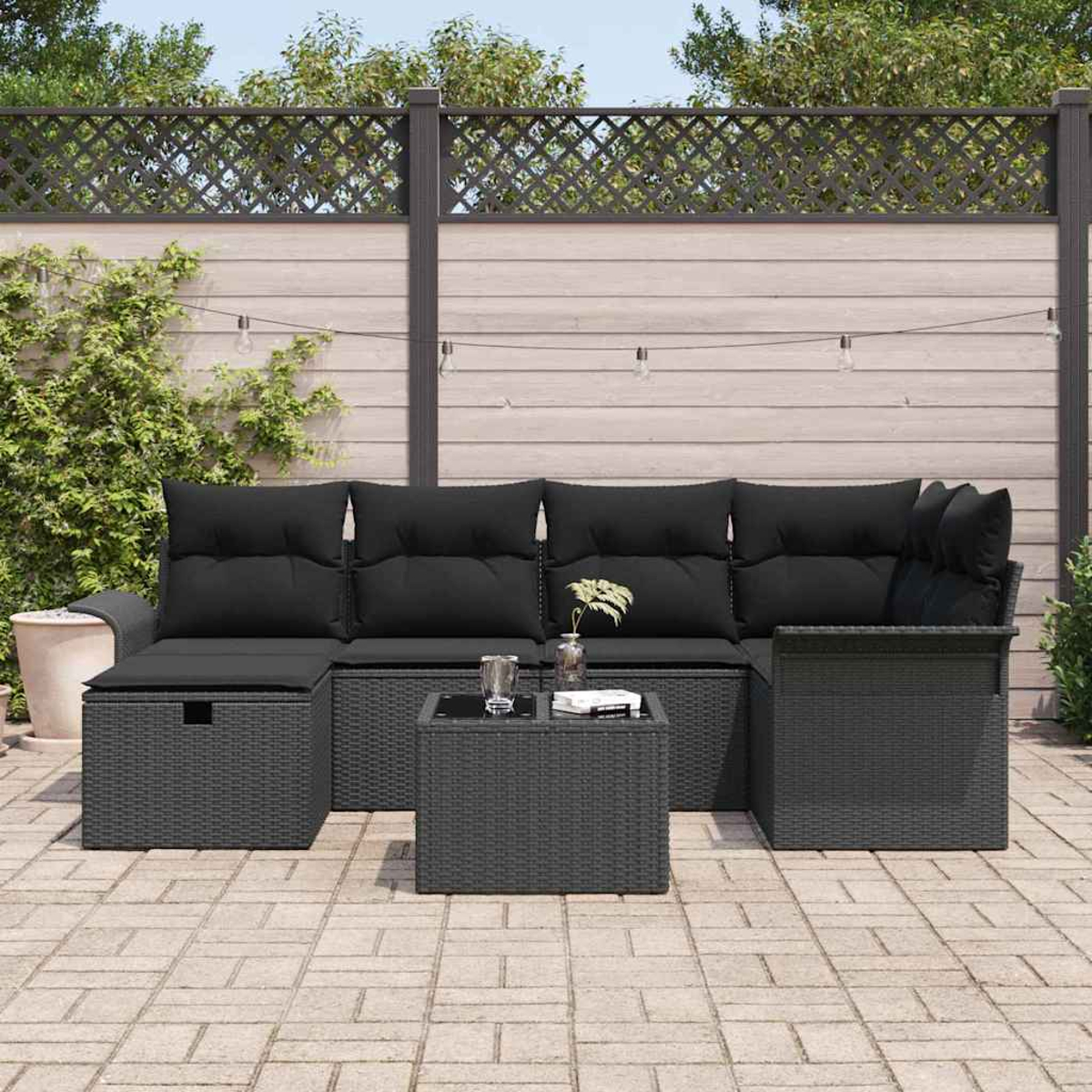 Garten-Terrassenset mit schwarzen Kissen und grauen Korbgeweben. Beinhaltet ein Ecksofa, einen Couchtisch und einen Einzelstuhl.