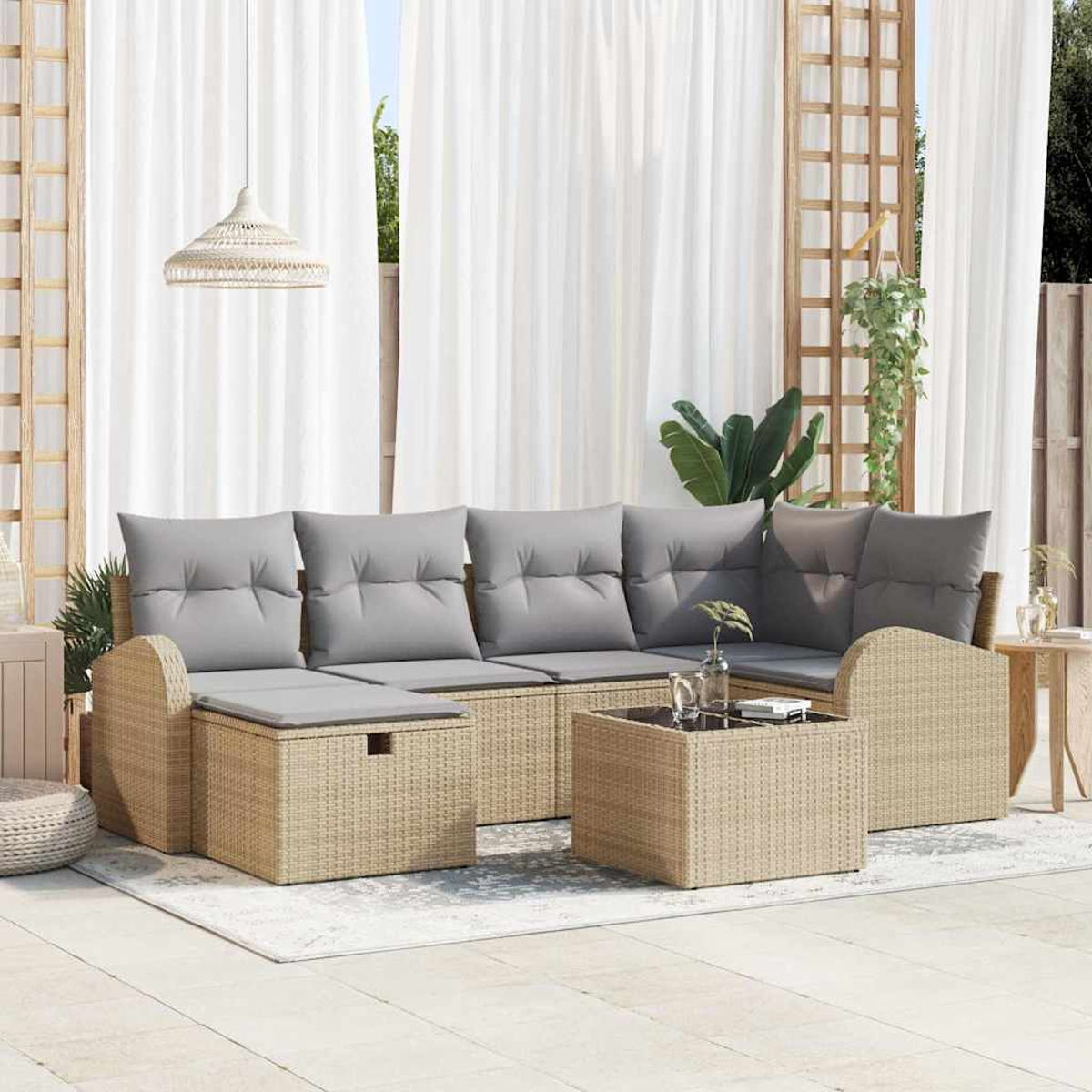 Garten-Sitzgruppe mit grauen Kissen, Couchtisch und weißen Vorhängen im Hintergrund. Pflanzen und eine Hängelampe sind ebenfalls sichtbar.