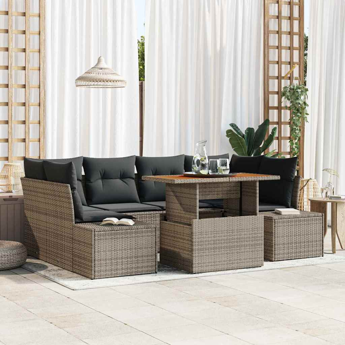 Outdoor-Sitzbereich. Graues Korbmöbel-Sofa mit schwarzen Kissen und einem Tisch. Weiße Vorhänge und eine Hängelampe sind sichtbar.