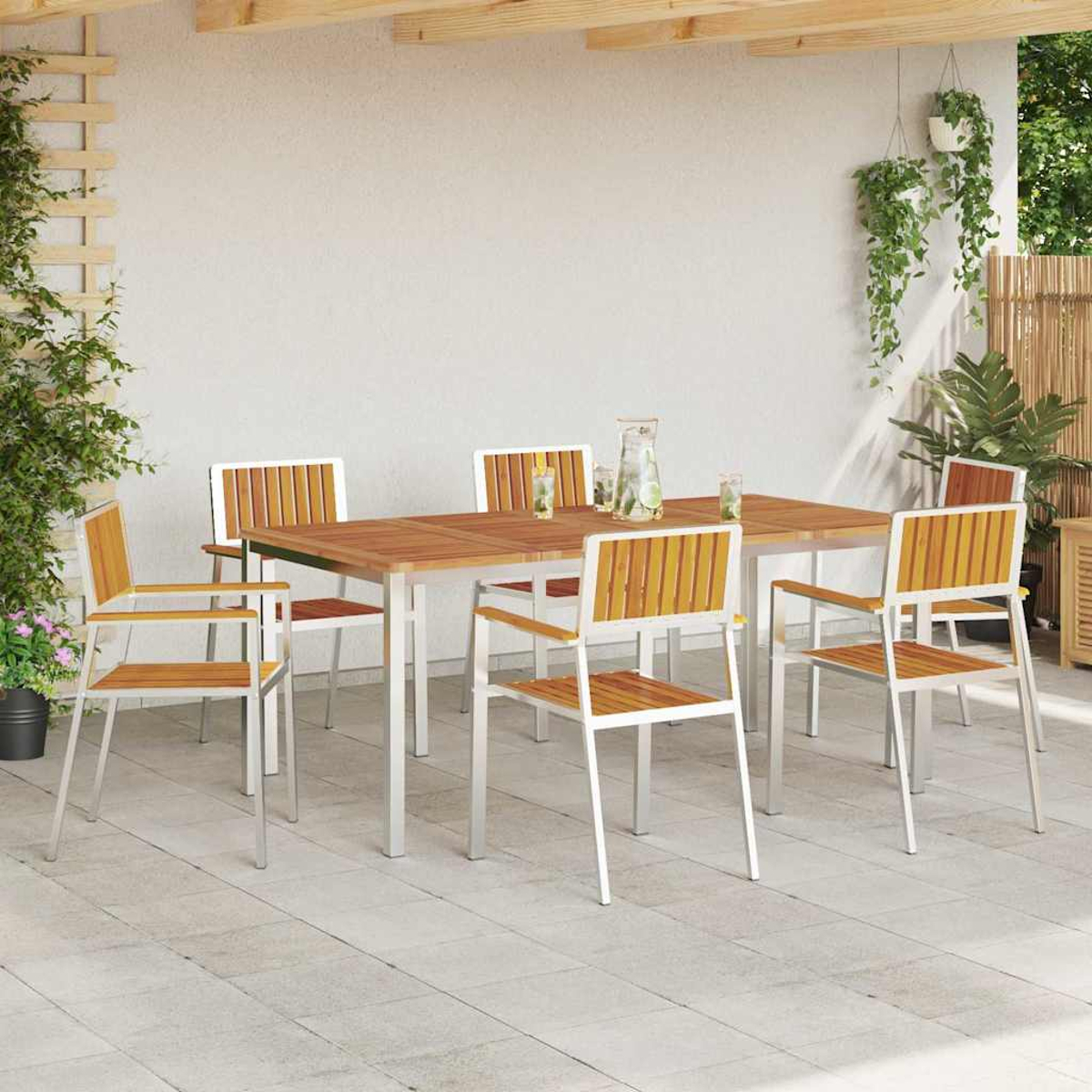 Ein Holztisch und Stühle auf einer Terrasse. Die Stühle haben weiße Rahmen und Holzsitzflächen. Pflanzen sind im Hintergrund sichtbar.
