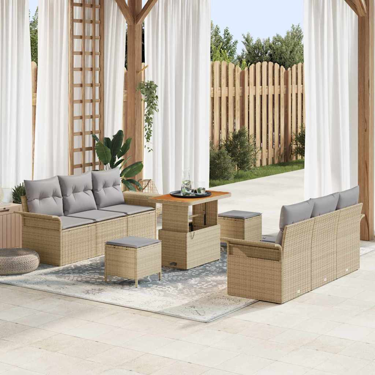 Garten-Terrassen-Set mit beigefarbenen Sofas, grauen Kissen, einem Tisch mit Hubtisch und Hockern, auf einem Teppich, mit weißen Vorhängen.