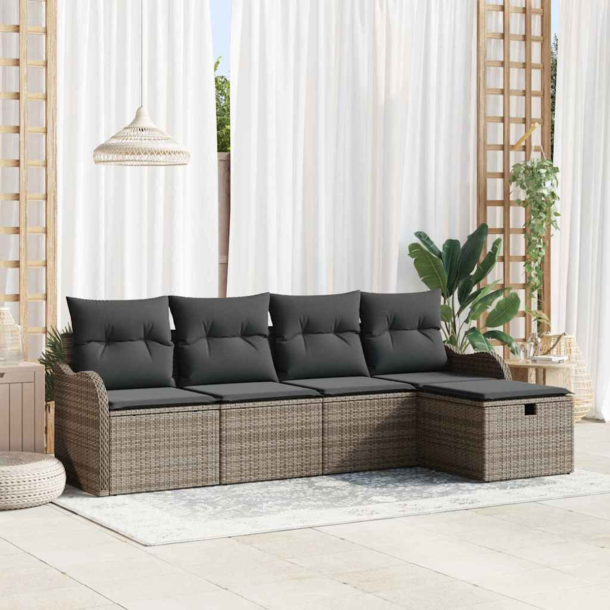 Garten-Wicker-Sofa mit grauen Kissen. Dahinter sind durchsichtige weiße Vorhänge und Hängepflanzen zu sehen, die eine entspannte Atmosphäre schaffen.