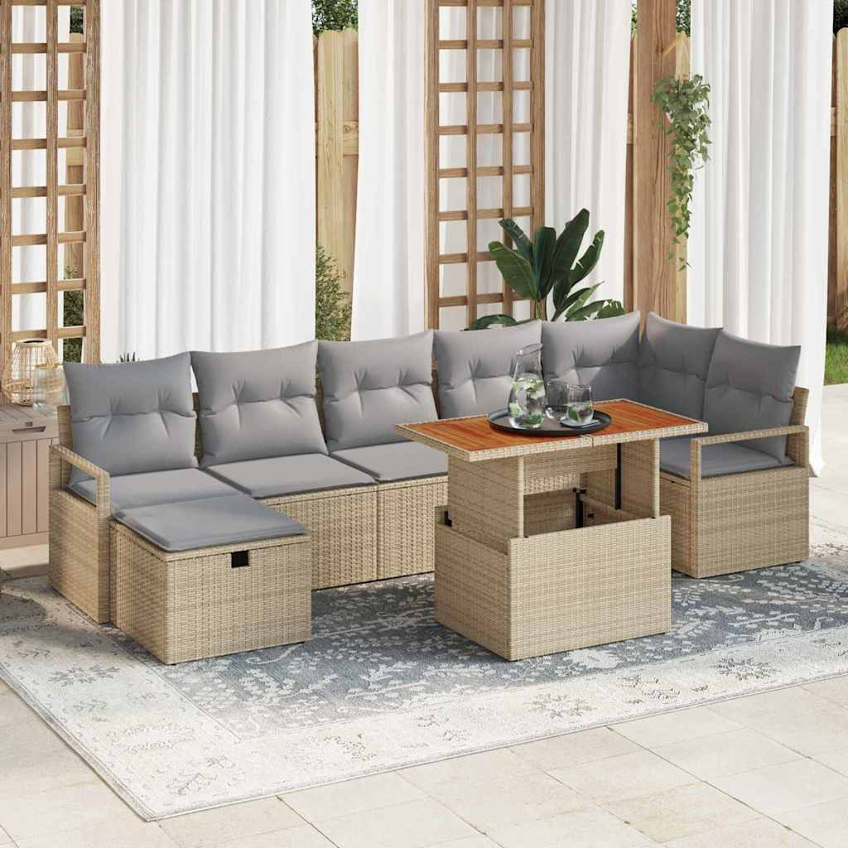 Garten-Wicker-Sofagarnitur mit grauen Kissen und einem Holztisch. Durchsichtige weiße Vorhänge und ein gemusterter Teppich vervollständigen die Szene.