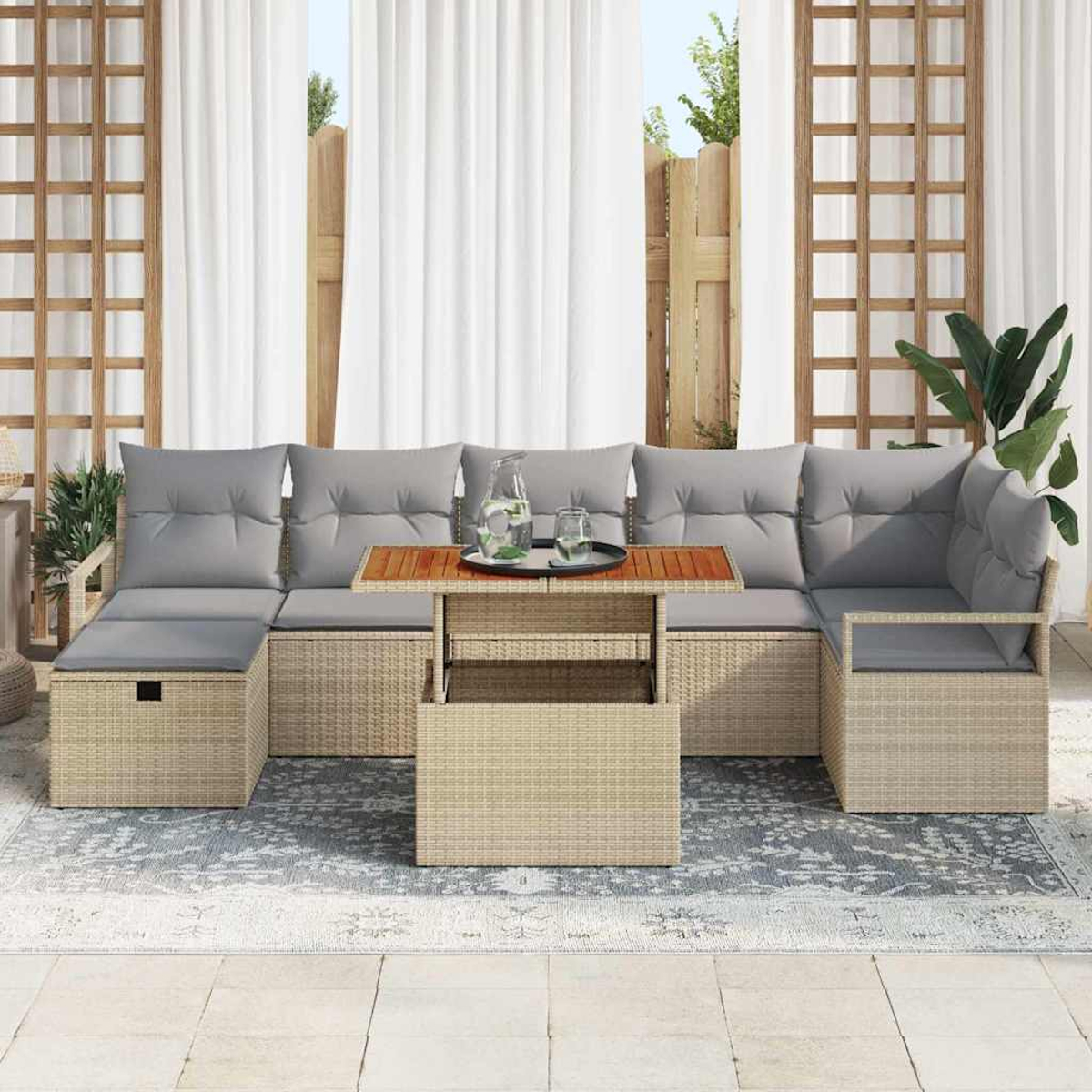 Gartenmöbel-Set aus Korbgeflecht mit grauen Kissen auf einem gemusterten Teppich, Tisch für Getränke gedeckt.