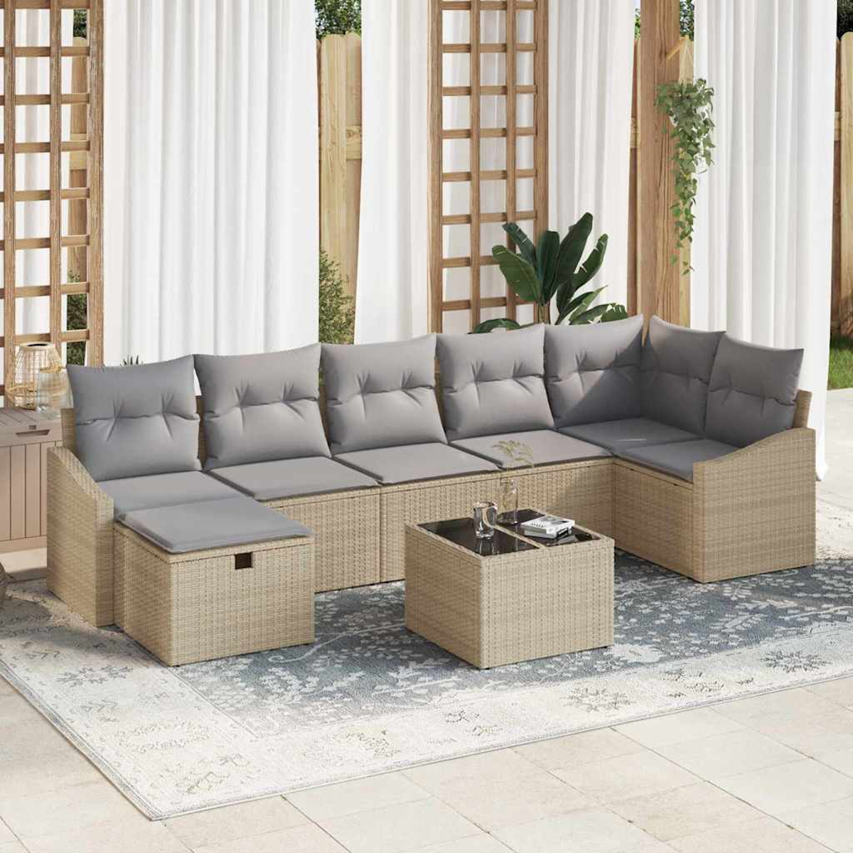 Outdoor-Ecksofa mit grauen Kissen und einem passenden Couchtisch. Auf einem Teppich mit weißem Vorhanghintergrund.