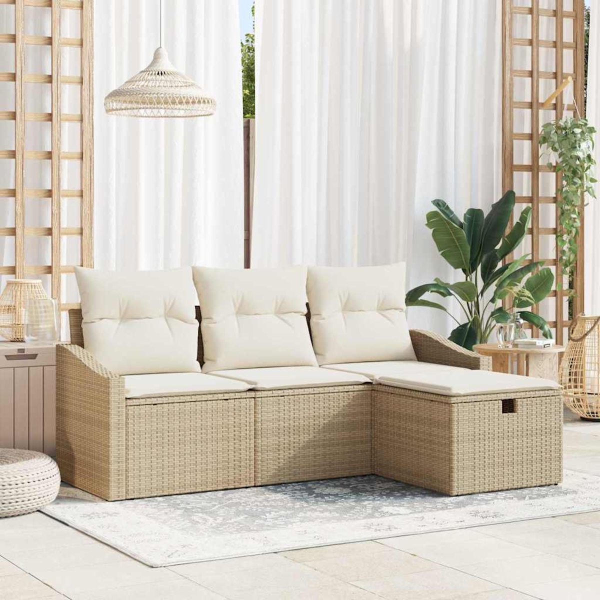 Beige Korbmöbel mit cremefarbenen Kissen auf einer Terrasse. Dahinter weiße Vorhänge und Pflanzen.