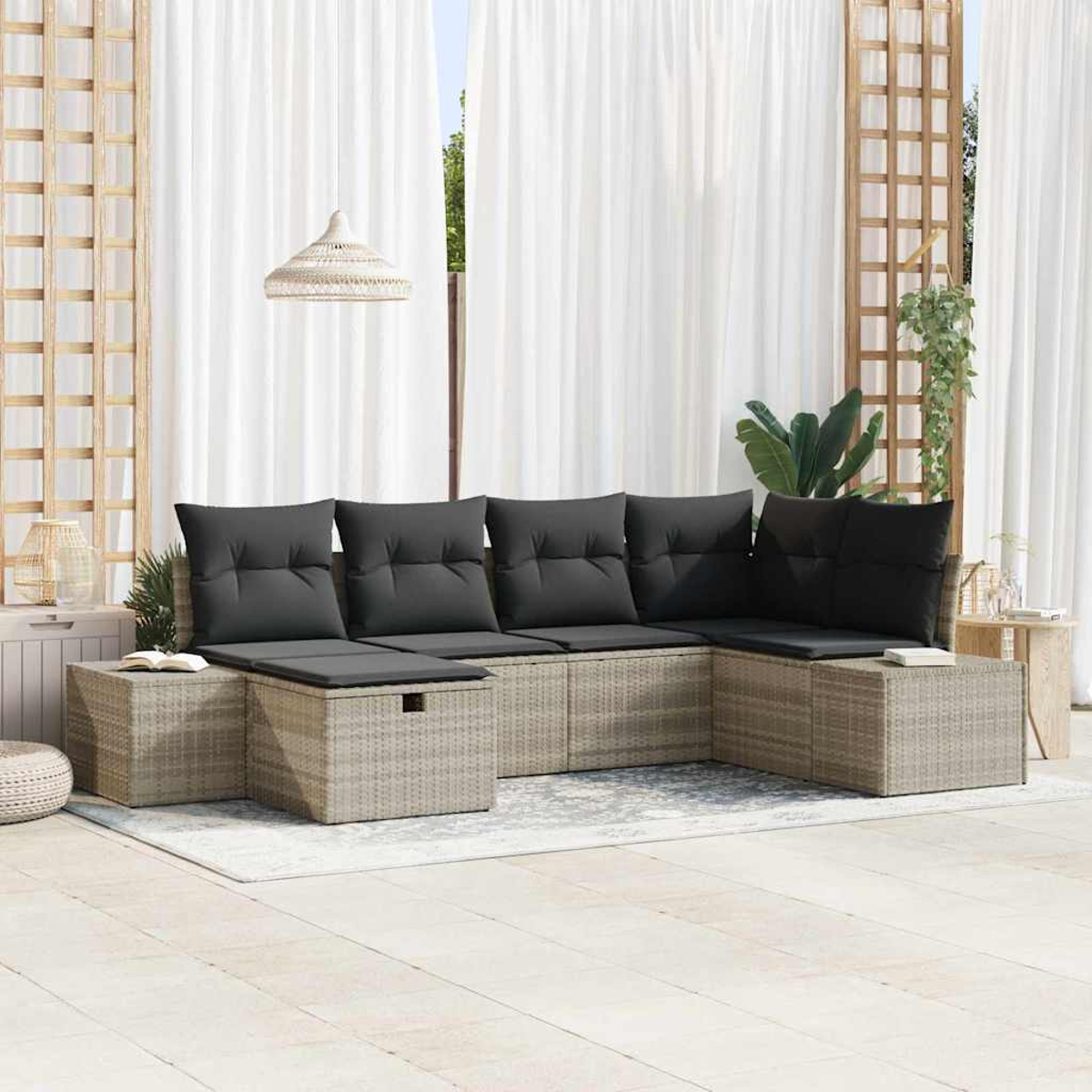 Outdoor-Ecksofa mit schwarzen Kissen. Inklusive Beistelltischen, Teppich und weißen Vorhängen im Hintergrund. Holzgitter und Hängelampe.
