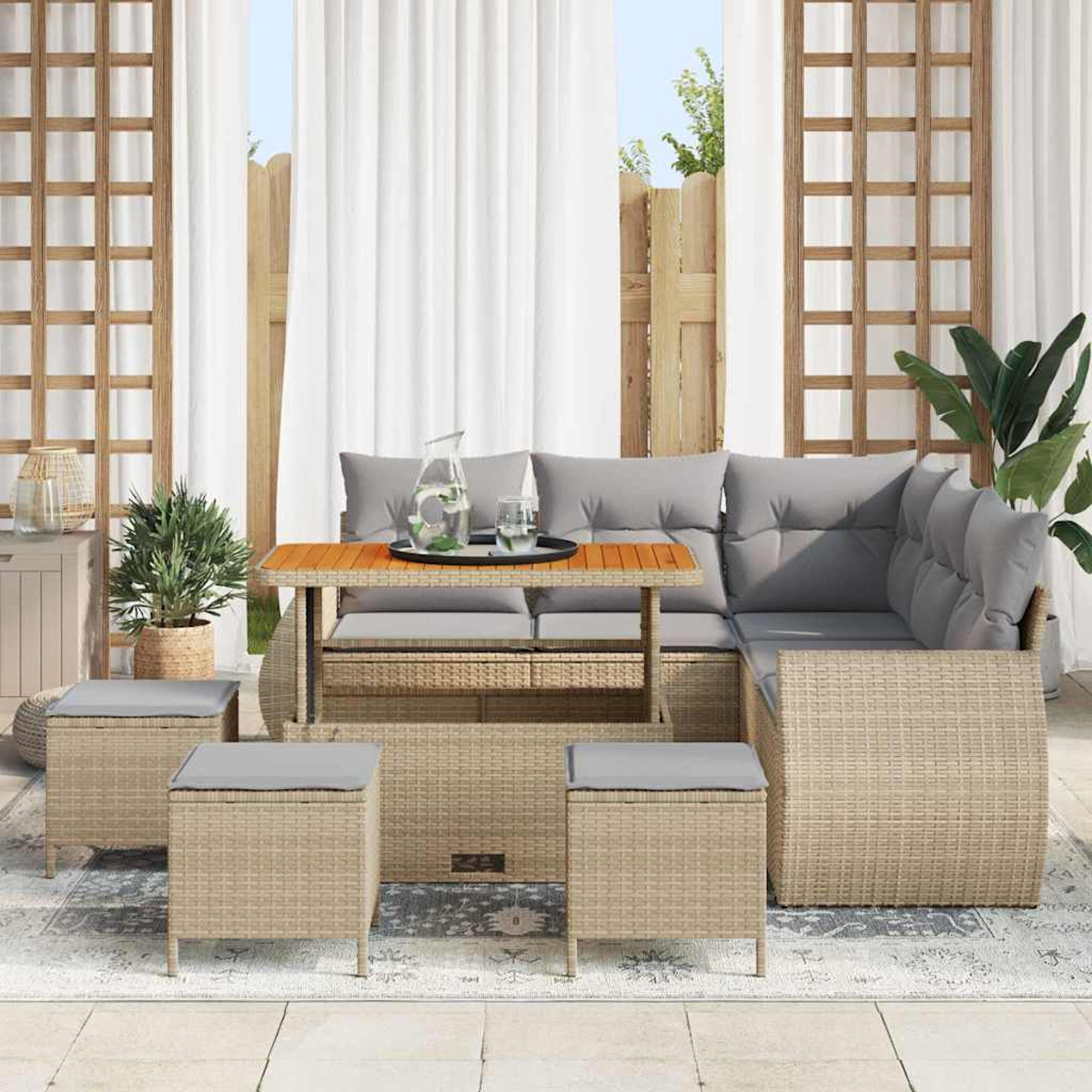 Garten-Sitzgruppe mit Sofa, Tisch und Hockern. Graue Kissen, Holztisch und beigefarbene Webstruktur. Pflanzen und Vorhänge im Hintergrund.