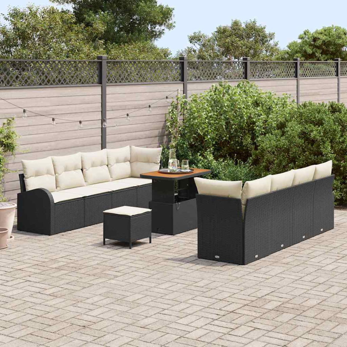 Schwarzes Outdoor-Geflechtmöbel-Set mit beigen Kissen. Enthält ein Sofa, zwei Sessel, einen Tisch und einen kleinen Hocker auf einer Terrasse.