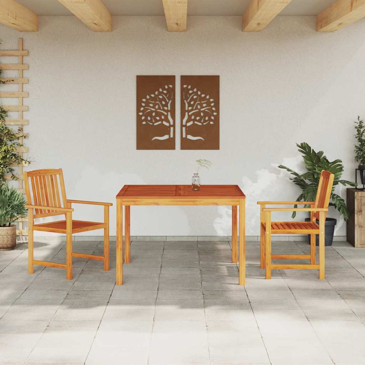 Essgruppe im Freien. Holztisch und Stühle auf einer Terrasse. Zwei Wandkunstwerke mit Baumdesigns. Pflanzen und ein Spalier sind sichtbar.