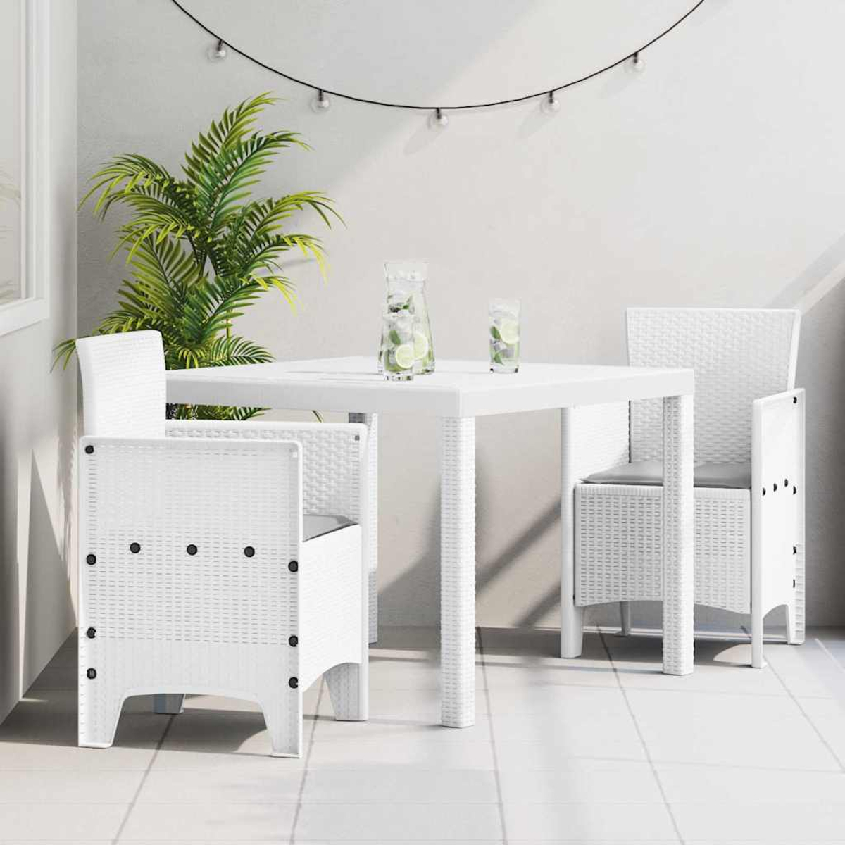 Weißes Terrassenset mit Tisch, Stühlen, Getränken und einer Pflanze. Lichterketten hängen darüber. Die Szene befindet sich auf einem Fliesenboden.
