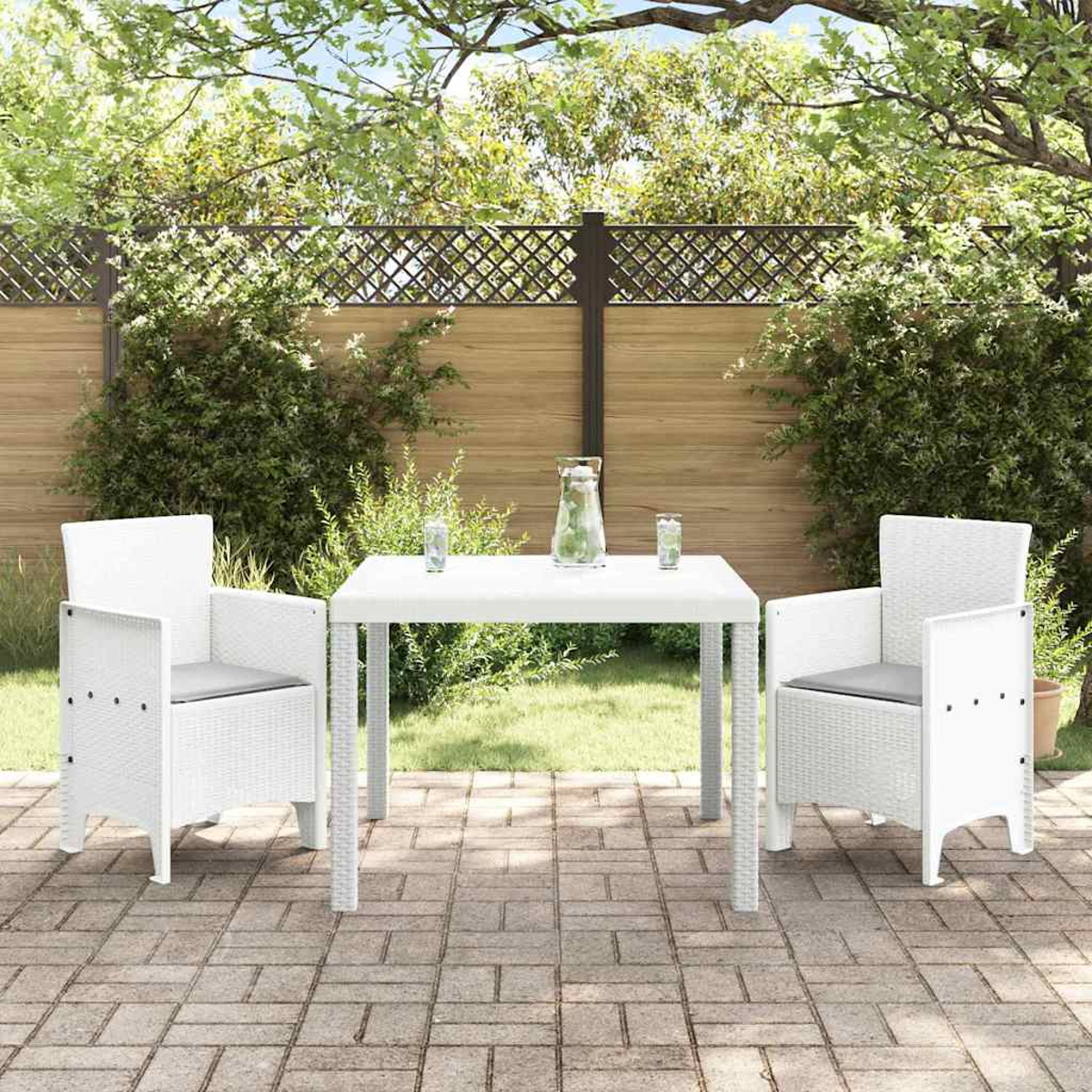 Szene auf der Außenterrasse mit weißem Tisch, Stühlen und Backstein-Patio. Hintergrund mit Grün, Zaun und Bäumen.