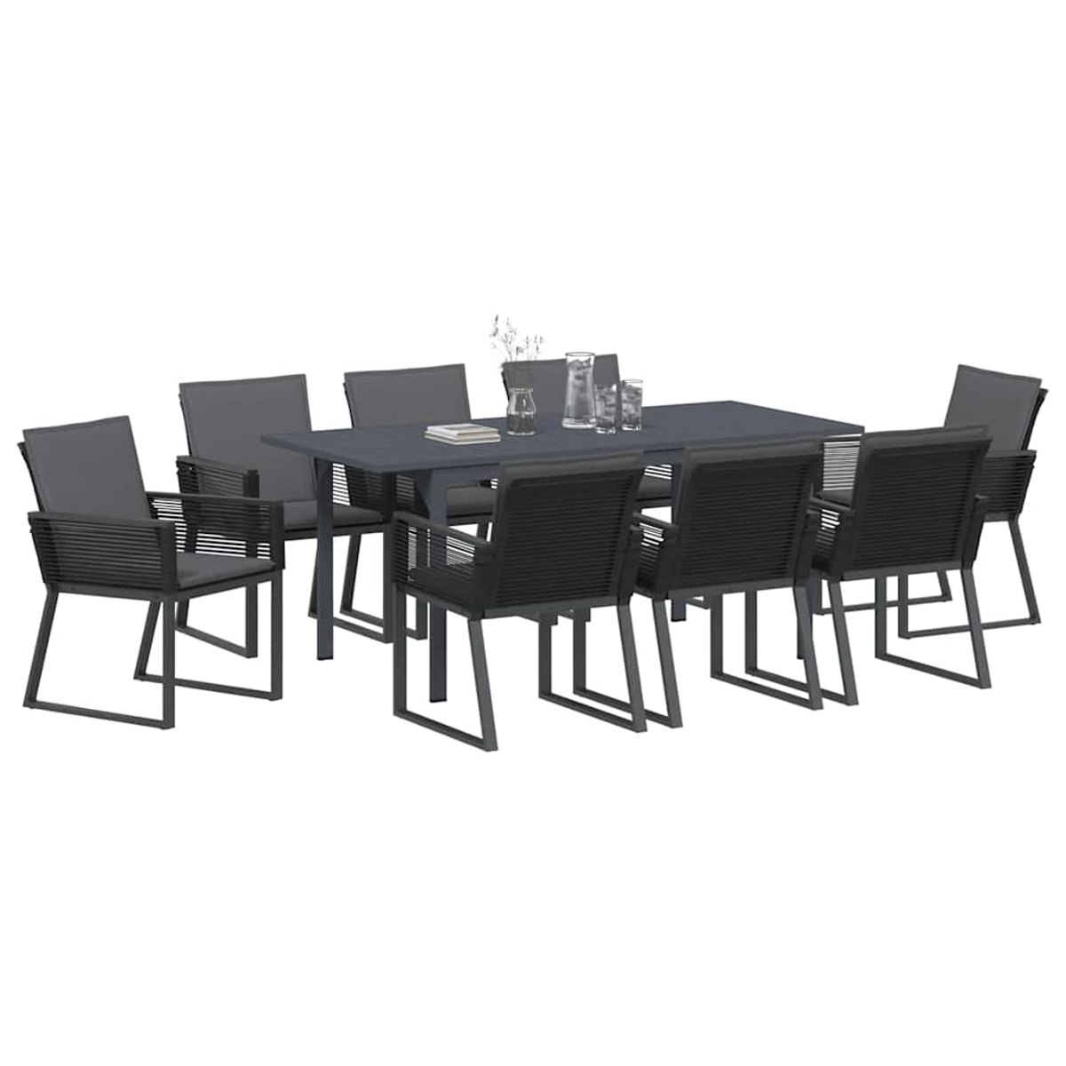 Ein Ess-Set mit einem grauen Tisch und acht Stühlen. Die Stühle haben schwarze gewebte Rückenlehnen und graue Kissen. Gläser stehen auf dem Tisch.