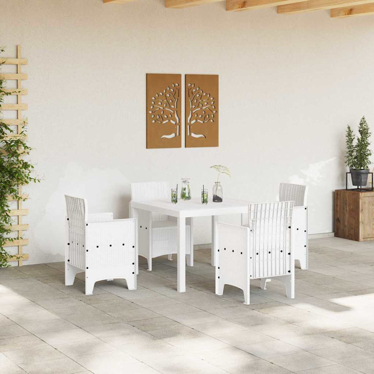 Outdoor-Setting mit weißen Möbeln und zwei baumförmigen Wandkunstwerken. Pflanzen und eine Holzkiste sind sichtbar.