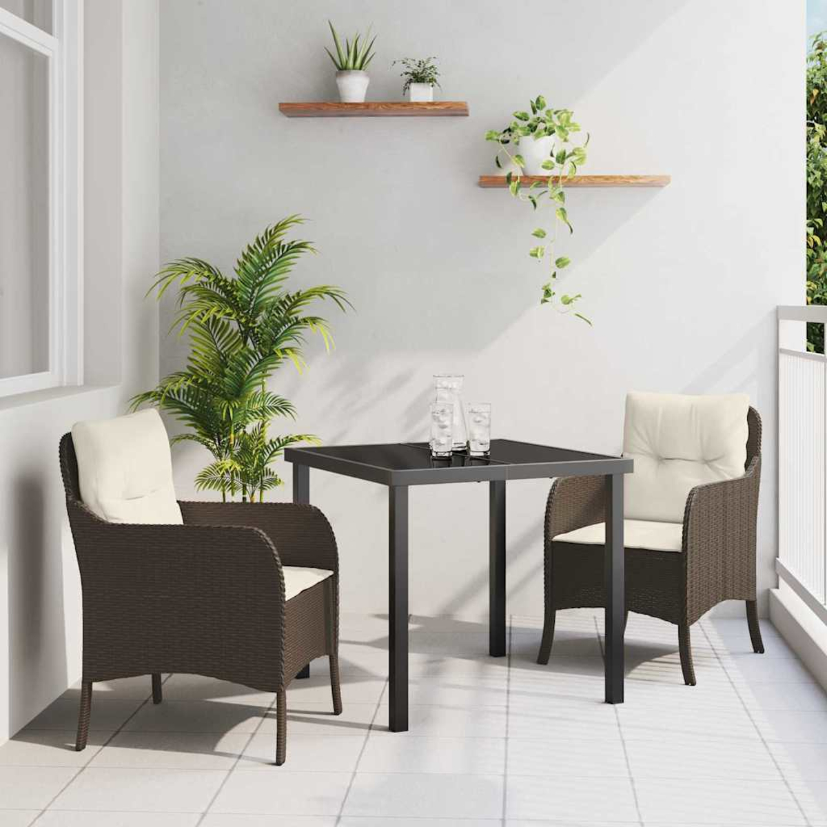 Eine Balkonszene mit Tisch, zwei Stühlen und Pflanzen. Die Stühle haben cremefarbene Kissen, der Tisch hat eine schwarze Oberfläche. Regale mit Pflanzen an der Wand.