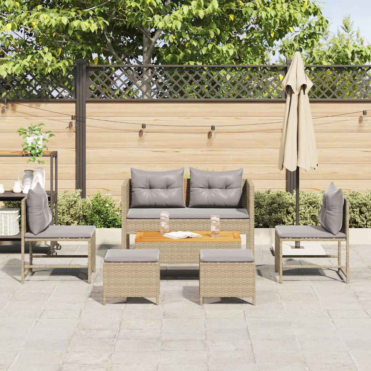 Garten-Terrassenset mit Sofa, Stühlen und Hockern. Beige Möbel mit grauen Kissen. Beiger Sonnenschirm. Holzzaun im Hintergrund.